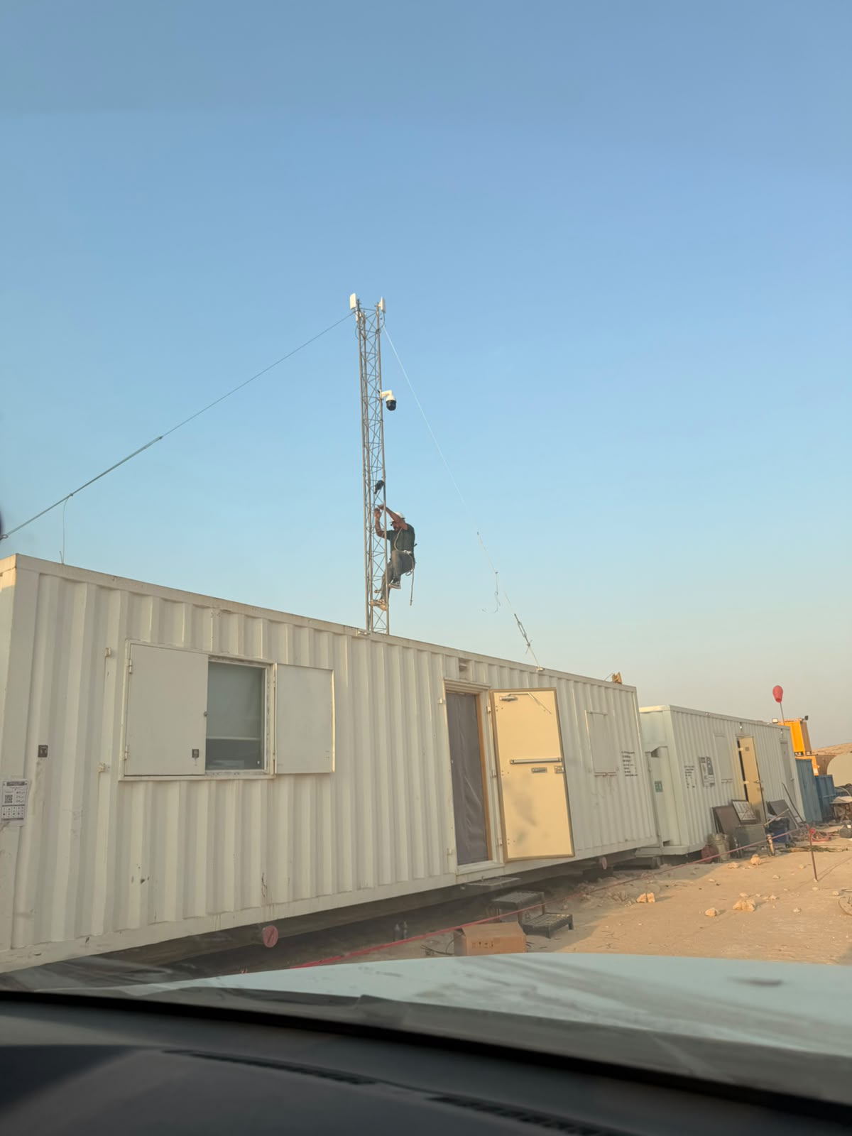 Technician installing a surveillance camera on a communications mast
